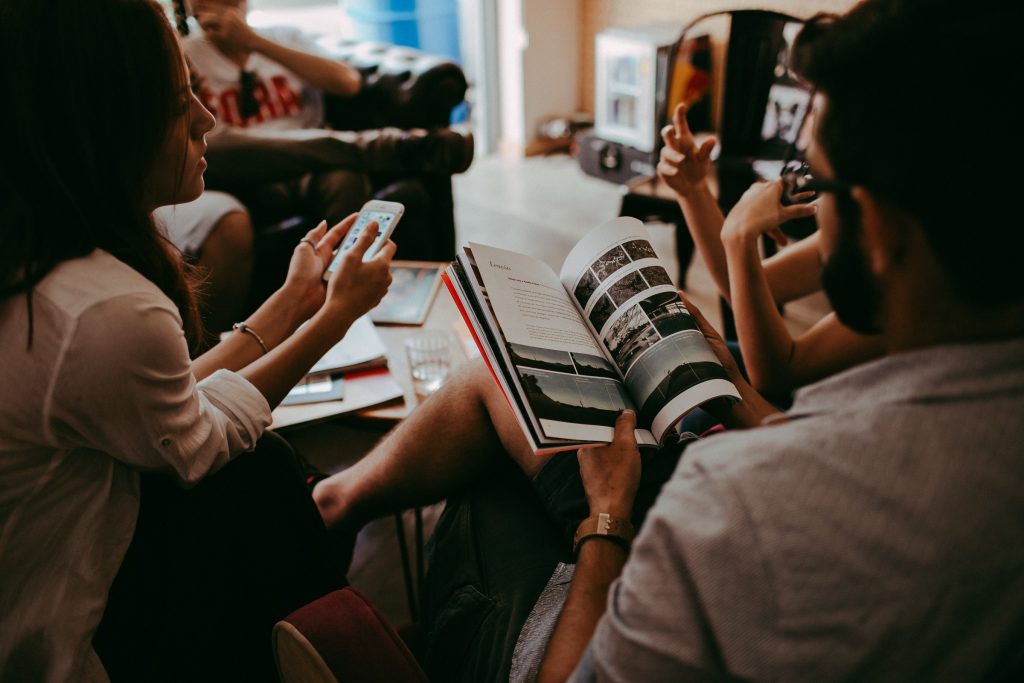 people sitting on chairs talking and reading